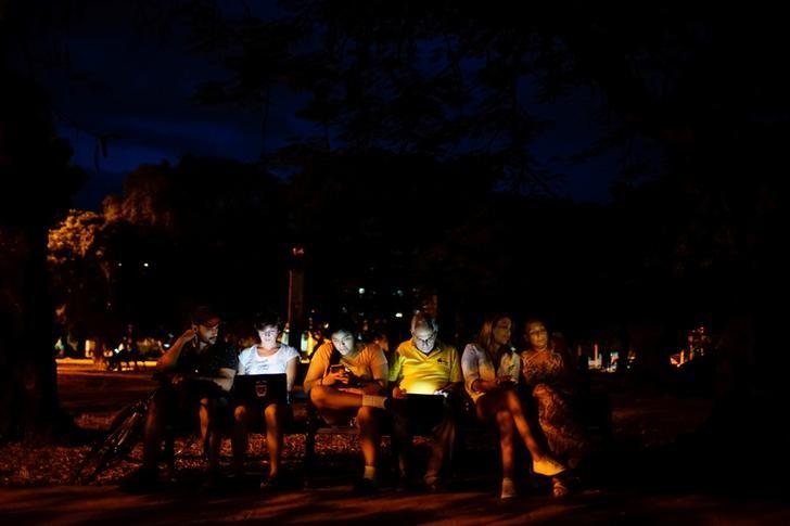 Imagen de archivo de gente conectada a Internet en una zona de acceso en un parque público en La Habana